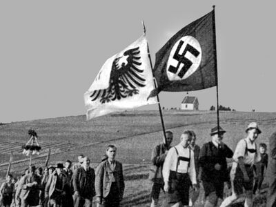 Sektionsmitglieder mit Hakenkreuz-Fahne auf dem Weg zur Einweihung des AV-Hauses Oberreifenberg, 1935.