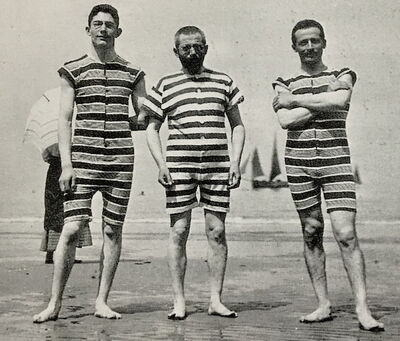 Hugo Bauer steht in Badekleidung am Meer oder einem See.